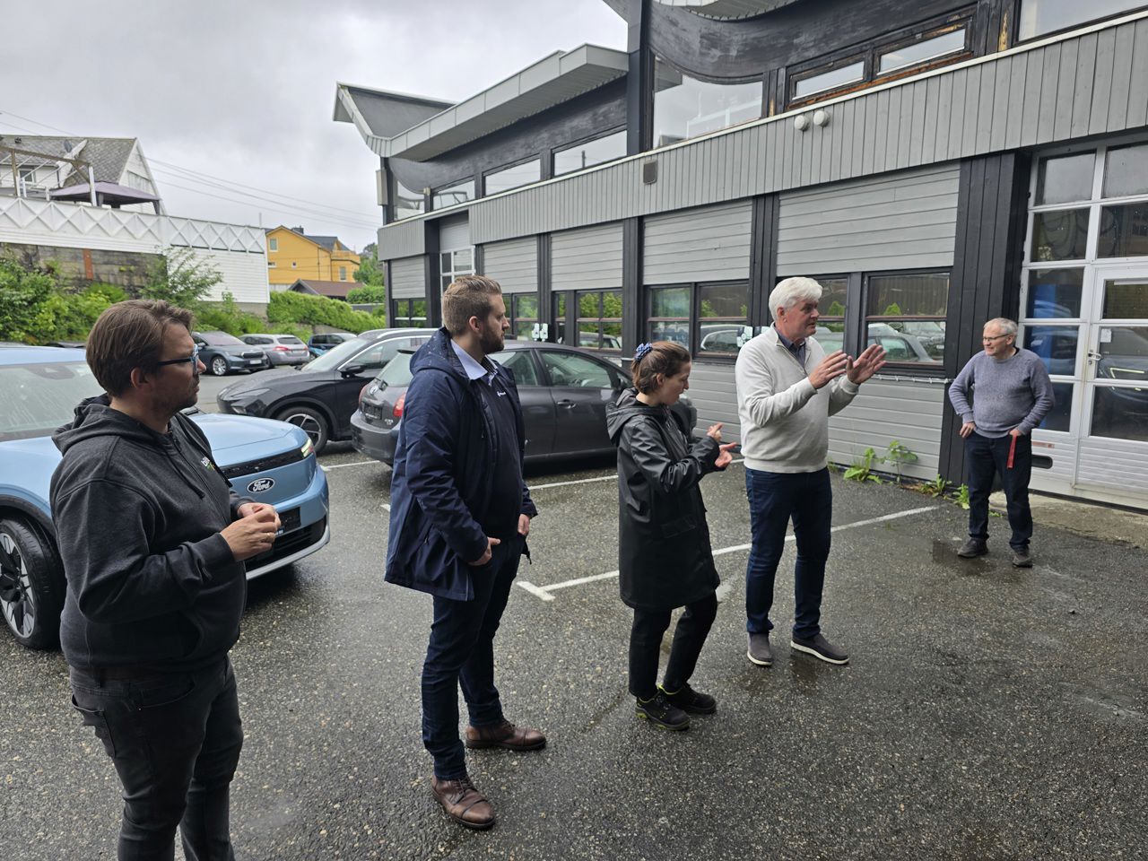 To frå Kverneland Bil, ein lærar, assisterande rektor og ein teiknspråktolk på parkeringsplassen utanfor bilverkstadhallen.
