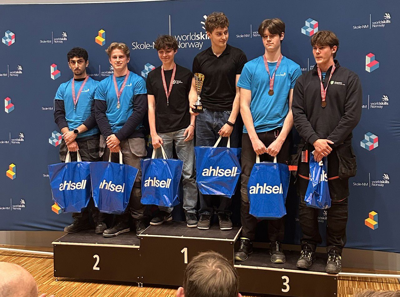 Dei tre beste laga i elektrofaget står på sigerspallen. Alle har fått medaljar og ein premiepose, vinnarlaget har også fått pokal.