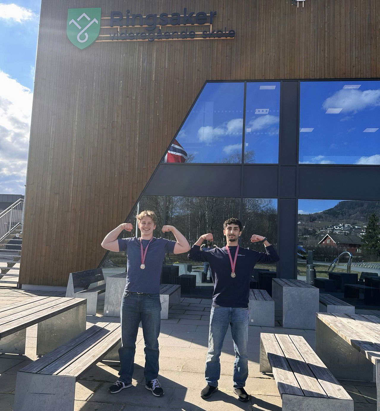 Glade sølvvinnarar fleksar musklar utanfor Ringsaker vgs.