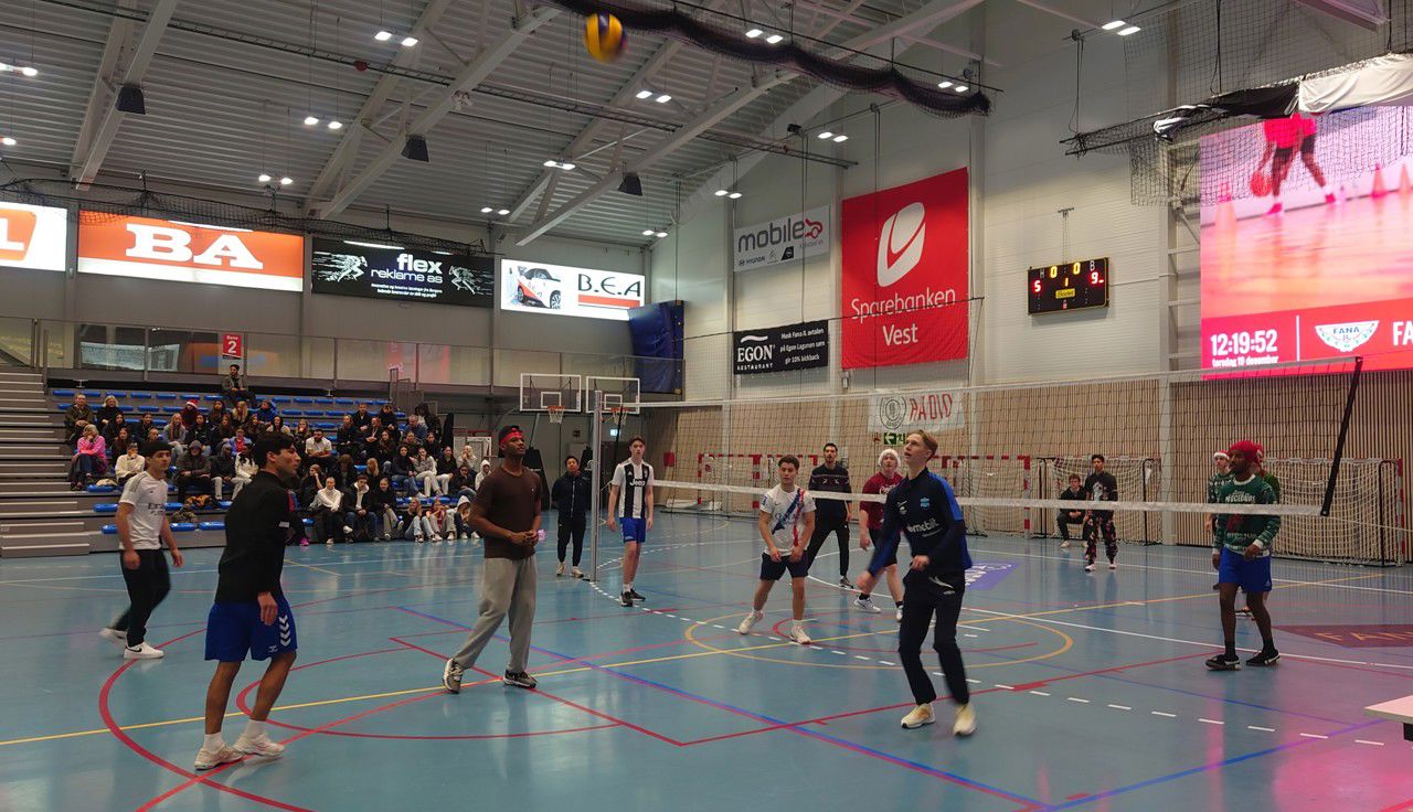Augeblinksbilde frå gutefinalen: Spelarane på begge sider speidar mot ballen høgt over nettet