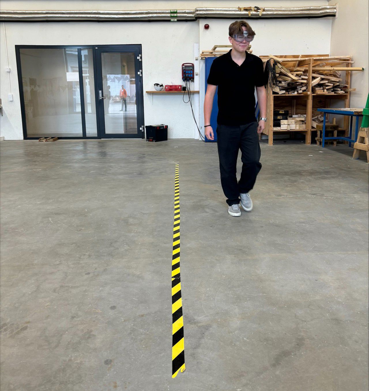 Ein elev med "promillebriller" går langs ei stripe med gul og svart tape.