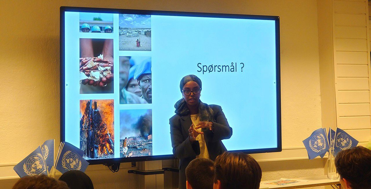 Insaaf Ali Ismail står foran siste bildet i presentasjonen: "Spørsmål?"